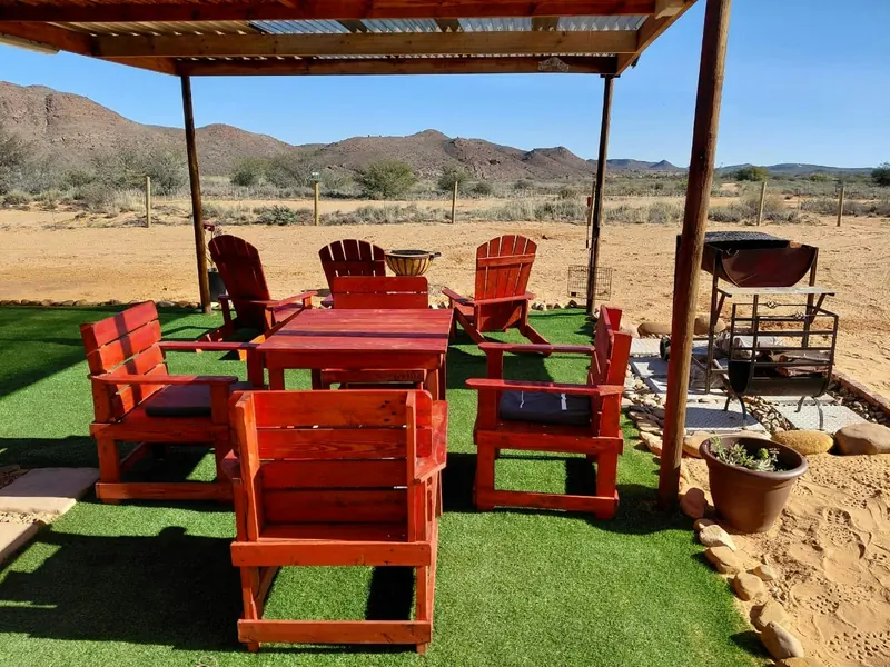 An outdoor table under a shade roof looking out over the Karoo veld near Ladismith